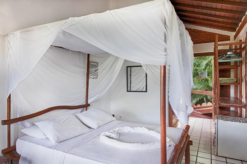 Novos Baianos Hostel E Pousada بورتو سيغورو المظهر الخارجي الصورة A mosquito net over a bed