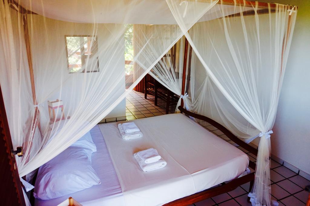 Novos Baianos Hostel E Pousada بورتو سيغورو المظهر الخارجي الصورة A mosquito net over a bed